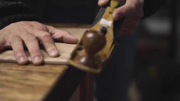 un falegname usando una pialla a mano livella la superficie di un grezzo di legno di noce video