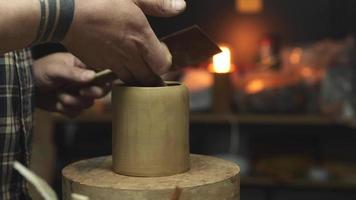 A potter makes a clay teapot with his own hands