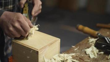 um carpinteiro planeja uma caixa de madeira com uma plaina manual video