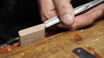 carpintero en el taller hace muebles con una herramienta de mano