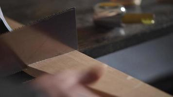 carpinteiro serrando uma peça de trabalho com uma serra japonesa video