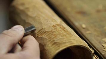 carver cuts wooden detail on woodworking chisel video