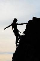 hermoso físico de niña escalando una pared rocosa foto