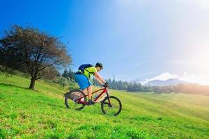 un joven montando una bicicleta de montaña cuesta abajo foto