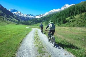 un par de amigos ciclistas con bicicletas de montaña en las montañas en un hermoso paisaje en los alpes foto