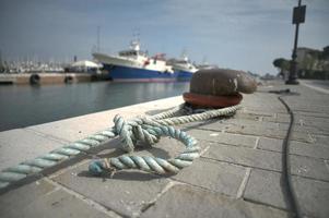 Dock of a harbor with a tied rope of a boat photo