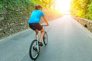 ciclista pedaleando cuesta arriba foto