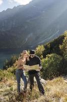 Young tourist couple, man and woman, on hiking path in mountains photo