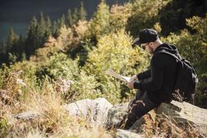 Man tourist relaxing on the top of a hill photo