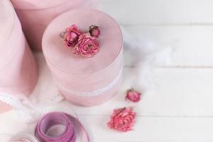 Beautiful pink round gift wrapping is decorated with narrowed roses. Romantic packaging concept photo