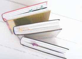 hardcovered books with dry flower bookmarks on a table. Bookshop background. reading and education, study and learning concept. photo