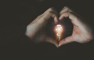 Finger hand heart love lightbulb lamp electric energy power glowing symbol business strategy intelligence planning creative idea vision brainstorm inspiration knowledge financial marketing.3d render photo