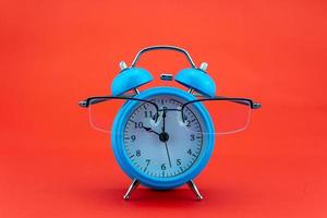 Concept Education or business Alarm clock and teacher glasses Business objects isolated on colorful background Back to school concept photo