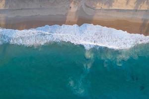 Aerial view sandy beach and waves Beautiful tropical sea in the morning summer season image by Aerial view drone shot, high angle view Top down sea waves photo