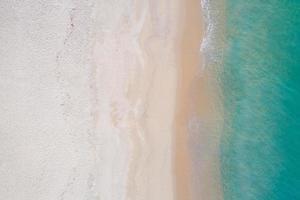 Aerial view sandy beach and waves Beautiful tropical sea in the morning summer season image by Aerial view drone shot, high angle view Top down sea waves beach beautiful sand in Phuket thailand photo