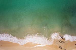 Aerial view sandy beach and waves Beautiful tropical sea in the morning in summer season beach. Aerial view drone shot. high angle view Top down sea photo