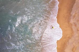 Aerial view top down of Local southern Thai fisherman uses his handmade fish trap and cicada sea on a beach in Phuket Thailand.Beautiful waves crashing on beach photo