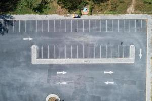 Aerial view drone top view shot of empty parking lot outdoors vehicles in the park. photo
