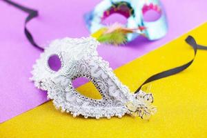 A festive,Beautiful white mardi gras or carnival mask on beautiful colorful paper background photo
