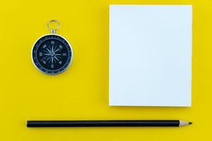 Top view business objects of white paper,pencil,and compass on paper work yellow background Flat lay composition. photo