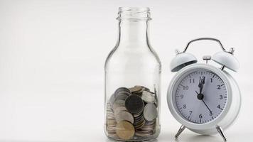 Concept Business finance and Shopping sale Coins in jar with White alarm clock Business objects isolated on white background photo