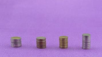 Row of coins thai baht isolated on purple paper background photo