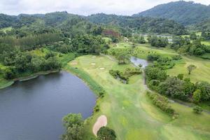 Aerial view drone shot of beautiful green golf field fairway and putting green Top down image for sport background and travel nature background Amazing view photo