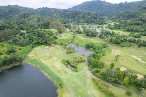Aerial view drone shot of beautiful green golf field fairway and putting green Top down image for sport background and travel nature background Amazing view photo