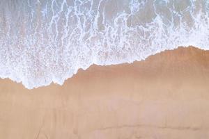 Aerial view sandy beach and waves Beautiful tropical sea in the morning summer season image by Aerial view drone shot, high angle view Top down sea waves photo