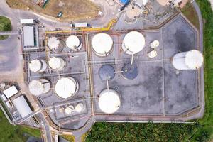 vista aérea del tanque de almacenamiento de combustible blanco en la planta de refinería de petróleo. vista superior tanques industriales blancos para gasolina y aceite. vista de ángulo alto estación de negocios de la industria. construcción de infraestructura foto