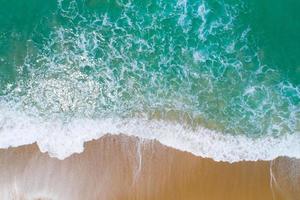 Aerial view sandy beach and waves crashing on sand. Beautiful tropical sea in the morning summer season image by Aerial view drone shot, high angle view Top down photo