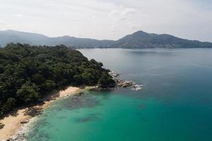 High angle view Tropical sea with wave crashing on seashore and high mountain located in Phuket Thailand aerial view drone top down Amazing nature view landscape Beautiful sea surface. photo
