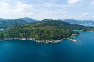 High angle view Tropical sea with wave crashing on seashore and high mountain located in Phuket Thailand aerial view drone top down Amazing nature view landscape Beautiful sea surface. photo