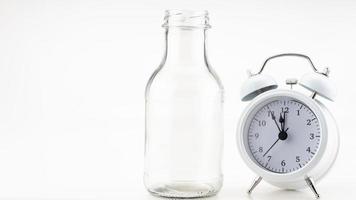 Banner of a glass of milk with white alarm clock on colorful background Copy space photo