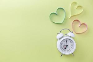 World heart day banner background White alarm clock and Heart symbol on table background Medical concept photo