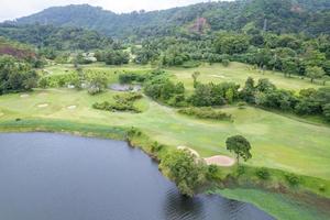 Aerial view drone shot of beautiful green golf field fairway and putting green Top down image for sport background and travel nature background Amazing view photo
