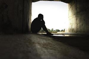 Asia you man sitting alone.He sitting in  under big tunnel.man very sad and depressed.sad,alone,suicide.despair. sickness.photo health and disappointment concept. photo