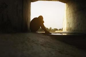 Asia you man sitting alone.He sitting in  under big tunnel.man very sad and depressed.sad,alone,suicide.despair. sickness.photo health and disappointment concept. photo