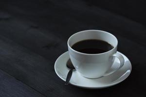 A cup of black coffee on wooden background photo