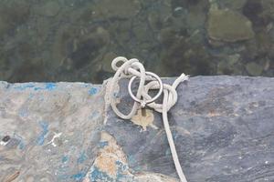 Marine knots on boats with ropes worn by water and sunlight photo