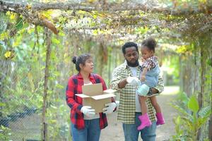 familia de raza mixta con hija pasando tiempo juntos en la granja orgánica. padre afroamericano foto