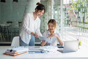 marketing, finanzas, contabilidad, planificación, equipo de mujeres de negocios analizan los resultados y ganancias de la empresa con estadísticas gráficas. use una computadora portátil y una calculadora para calcular el saldo de la empresa. foto