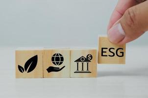 Hand put wooden cubes with ESG Environmental Social Governance symbol on table copy space.Business concepts. photo