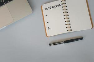 2022 goal notebook and pen on background. Top view copy space. photo