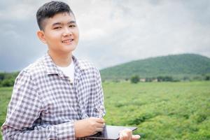 niño rural usando tableta manteniendo registros de trabajo en campos agrícolas foto