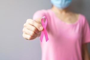 October Breast Cancer Awareness month, elderly Woman in pink T- shirt with hand holding Pink Ribbon for supporting people living and illness. International Women, Mother and World cancer day concept photo