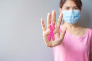 October Breast Cancer Awareness month, elderly Woman in pink T- shirt with hand holding Pink Ribbon for supporting people living and illness. International Women, Mother and World cancer day concept photo