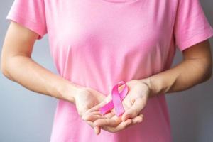 October Breast Cancer Awareness month, elderly Woman in pink T- shirt with hand holding Pink Ribbon for supporting people living and illness. International Women, Mother and World cancer day concept photo