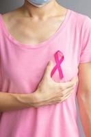 October Breast Cancer Awareness month, elderly Woman in pink T- shirt with hand holding Pink Ribbon for supporting people living and illness. International Women, Mother and World cancer day concept photo