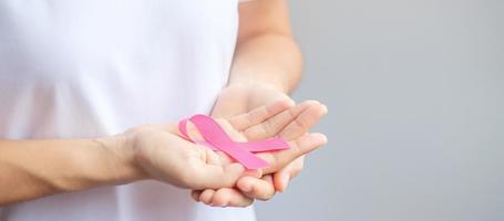 October Breast Cancer Awareness month, elderly Woman in white T- shirt with hand holding Pink Ribbon for supporting people living and illness. International Women, Mother and World cancer day concept photo